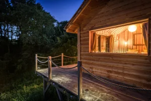Cabane des grands enfants en bois, éclairée la nuit Cabane des grands enfants en bois, éclairée la nuit