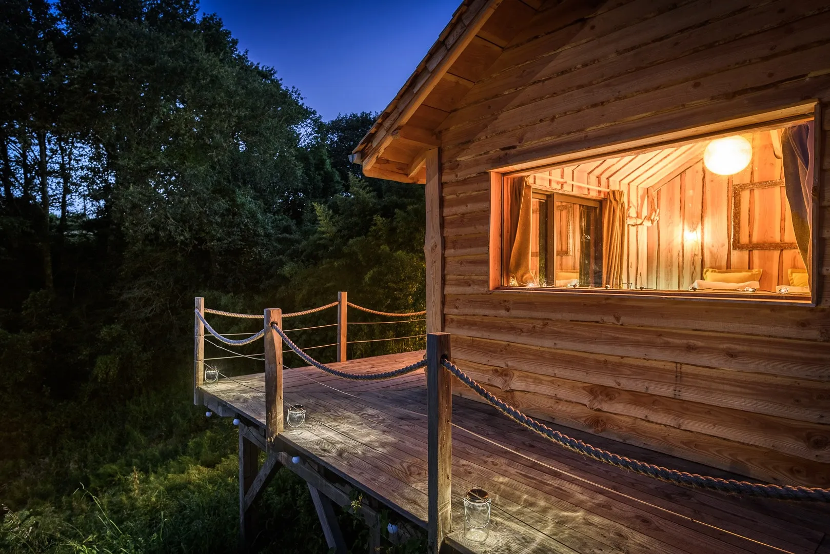 Cabane des grands enfants en bois, éclairée la nuit Cabane des grands enfants en bois, éclairée la nuit